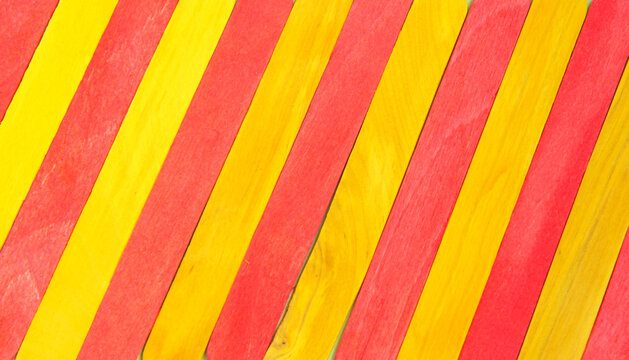 Colorful Ice Cream Stick. Red and yellow color. Diagonal abstract wooden sticks background. Colorful rainbow wooden popsicles