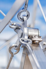 Metal silver structures shiny from industrial machines of various shapes against the background of a blue sky