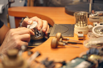 Male jeweler working with an engraving tool - obrazy, fototapety, plakaty
