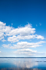 Naklejka na ściany i meble Beautiful blue cloudy sky and its reflection in water
