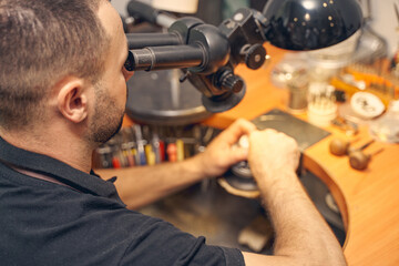 Craftsperson using a microscope in his work