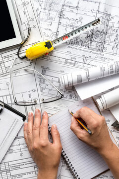 architect design working drawing sketch plans blueprints and making architectural construction model in home.