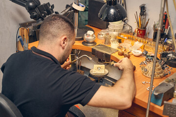 Male worker treating a pendant on the fire brick