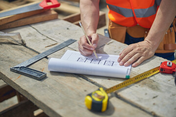 Caucasian male worker making changes to the house plan