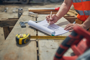 Caucasian male constructor drawing with a pencil