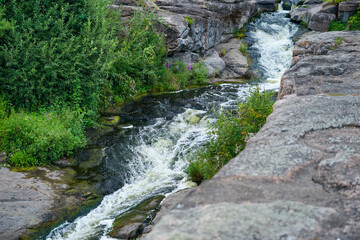 Fototapeta na wymiar mountain stream waterfall and green moss on the stone