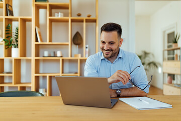 Using laptop in his home office.