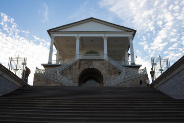 View from below of a wide staircase and a staircase with openwork railings leading to the gallery...