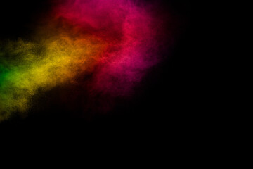 Explosion of colorful pigment powder on black background.Vibrant color dust particles textured background.