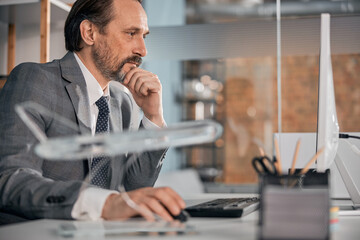 Handsome gentleman using desktop PC at work