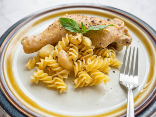 Garlic Butter Chicken with Pasta Main ingredient Garlic,Butter,Chicken,Pasta is placed on a white plate,Face with basil,White background