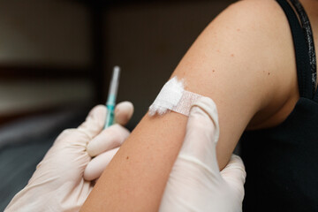 Girl with plaster on the shoulder from injection.