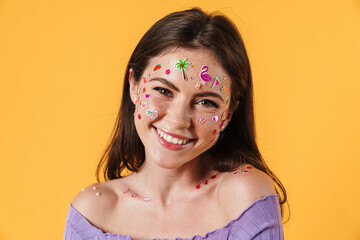 Image of young joyful woman with stickers on face smiling at camera