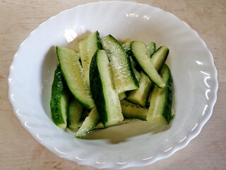 Sliced cucumber slices laid out on a white dish. View from above. Macro photography.
