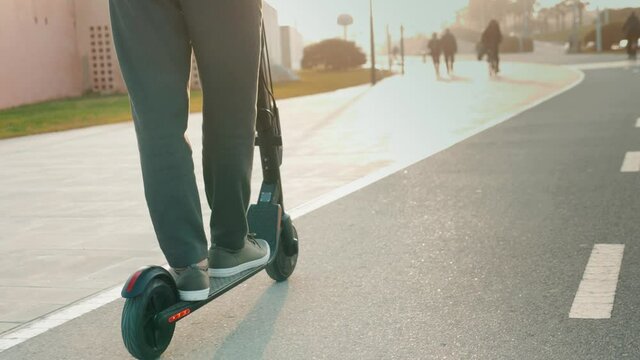 e-scooter rider, man ride sharing or rent personal eco transportation. man hipster riding an electric scooter road to work the modern way. Fast speed driving electric transport, day light