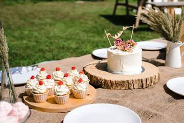 cupcakes with cream on a wooden tray outside