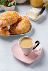 Cup of coffee and croissants on concrete background. French breakfast.