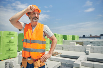 Male worker in a protective helmet standing outside