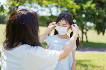 子どもにマスクを付けさせるお母さん