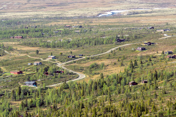 Naklejka premium Curved gravel road and family holiday cabins near Rondane national park in Norway.