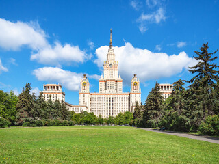 view of east facade of The Main Building of Moscow State University (Lomonosov State University of Moscow) and green lawn in yard in sunny summer day