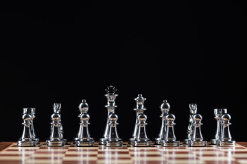 Silvery chess figures standing on chessboard