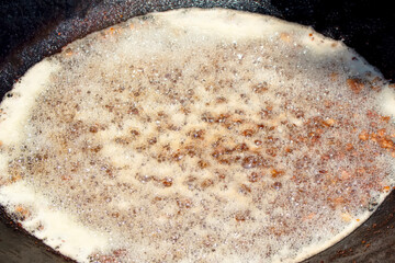 Roasting of fatty pieces of meat in the pot for cooking plov.