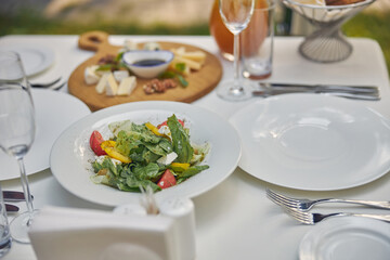 White plate with green salad for the diner