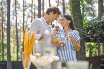 Smiling happy couple standing in landscape green park of rich restaurant