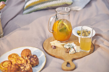 Beautiful serving jug with orange lemonade with cheese and olives