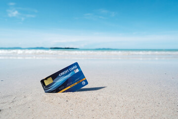 A blue credit card placed on a tropical beach - obrazy, fototapety, plakaty