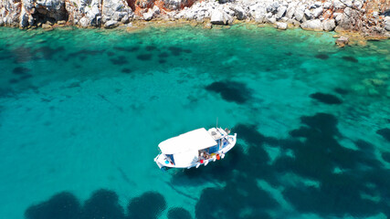 Aerial drone photo of beautiful fishing boat anchored in turquoise sea of Stafilos bay, Skopelos...