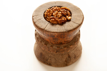 Walnuts in antique, wooden mortar.
