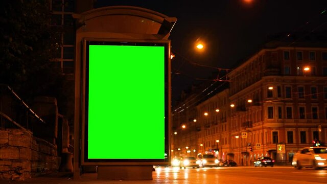 Bus stop sign ad on highway. Night traffic in the city