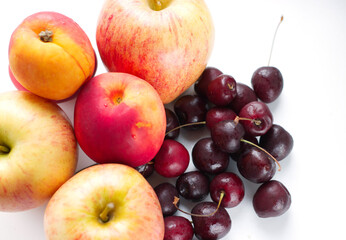 set of fruits, ripe apples and a handful of cherries on a light surface. Natural fruit dessert. A...