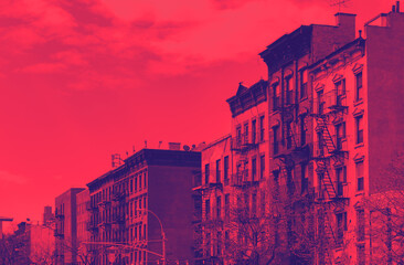 Block of old buildings in the East Village neighborhood of New York City with red and blue duotone color effect