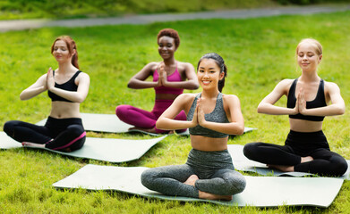 Wellness concept. Tranquil young women deep in meditation during their morning yoga class in nature