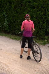 a woman is riding a bicycle on a country dirt road