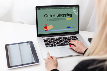 Online shopping website on laptop screen with female hands typing