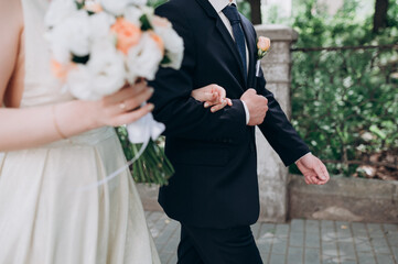 the bride holds the groom's arm