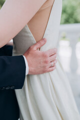 Obraz na płótnie Canvas the groom holds the bride by the waist with his hands