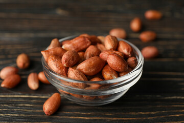 Bowl with peanut on wooden background. Vitamin food