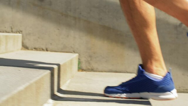 fitness, sport and healthy lifestyle concept - feet of young man running upstairs
