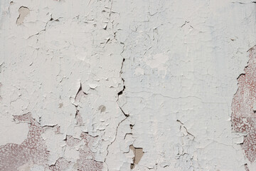 Grunge weathered shabby peeled white painted concrete surface wall with holes and cracks macro