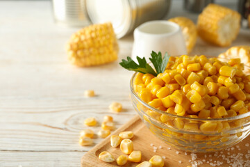 Composition with fresh raw corn on white wooden background, space for text