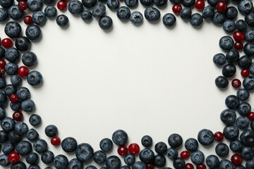 Frame made of fresh berries on white background, space for text