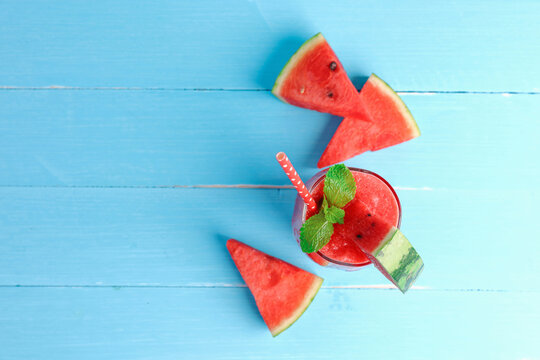 Cold watermelon smoothie drinks in the glass. Top view, Flat lay on blue wooden background with copy space.