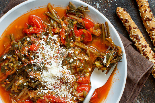 Healthy Sauteed green cicory and tomatoes topped with caccioricotta cheese