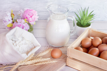 Jug of fresh milk. Flour and wheat ears eggs in the basket of grains