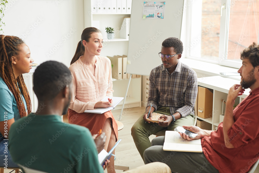 Canvas Prints multi-ethnic group of people sitting in circle while discussing strategy for business project in off